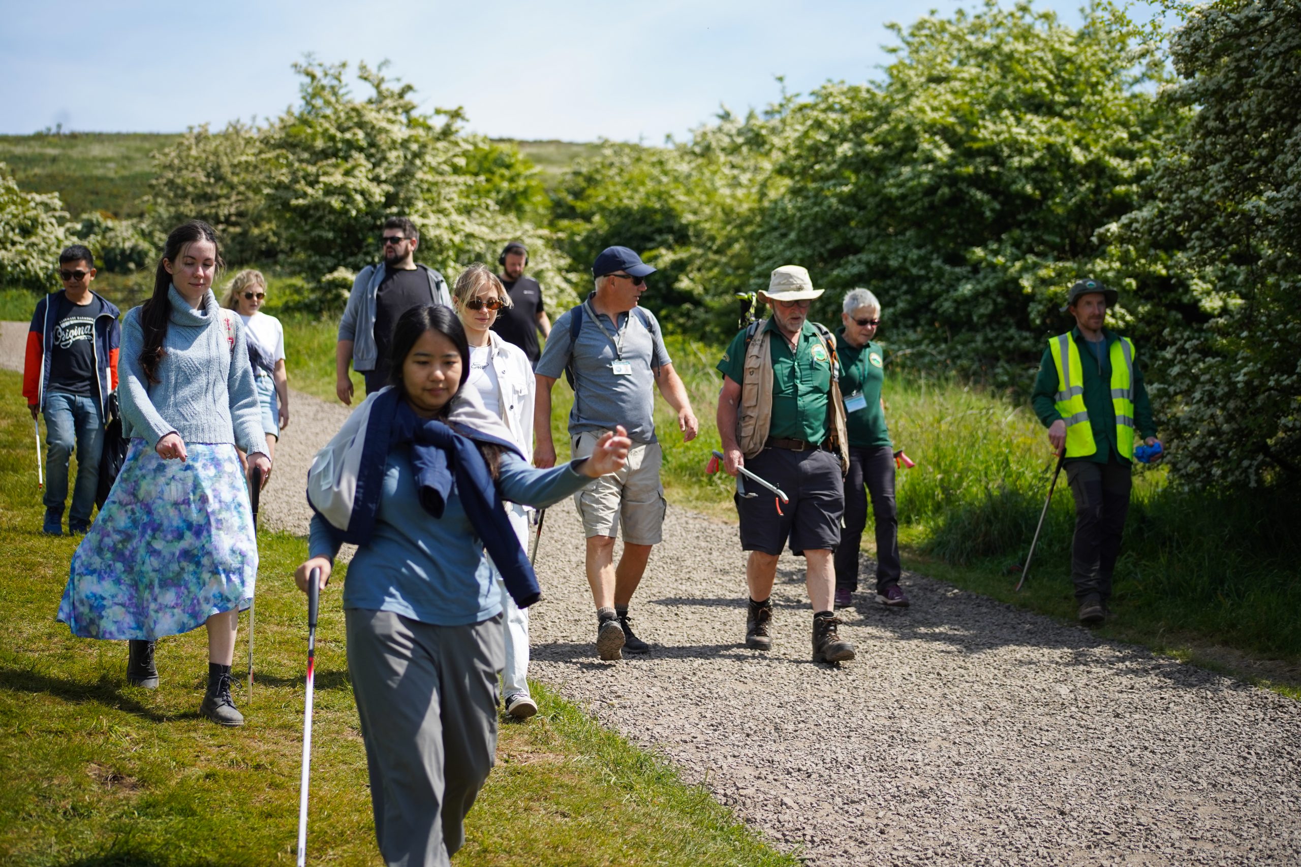 Group of employer supported volunteers walking with litter pickers